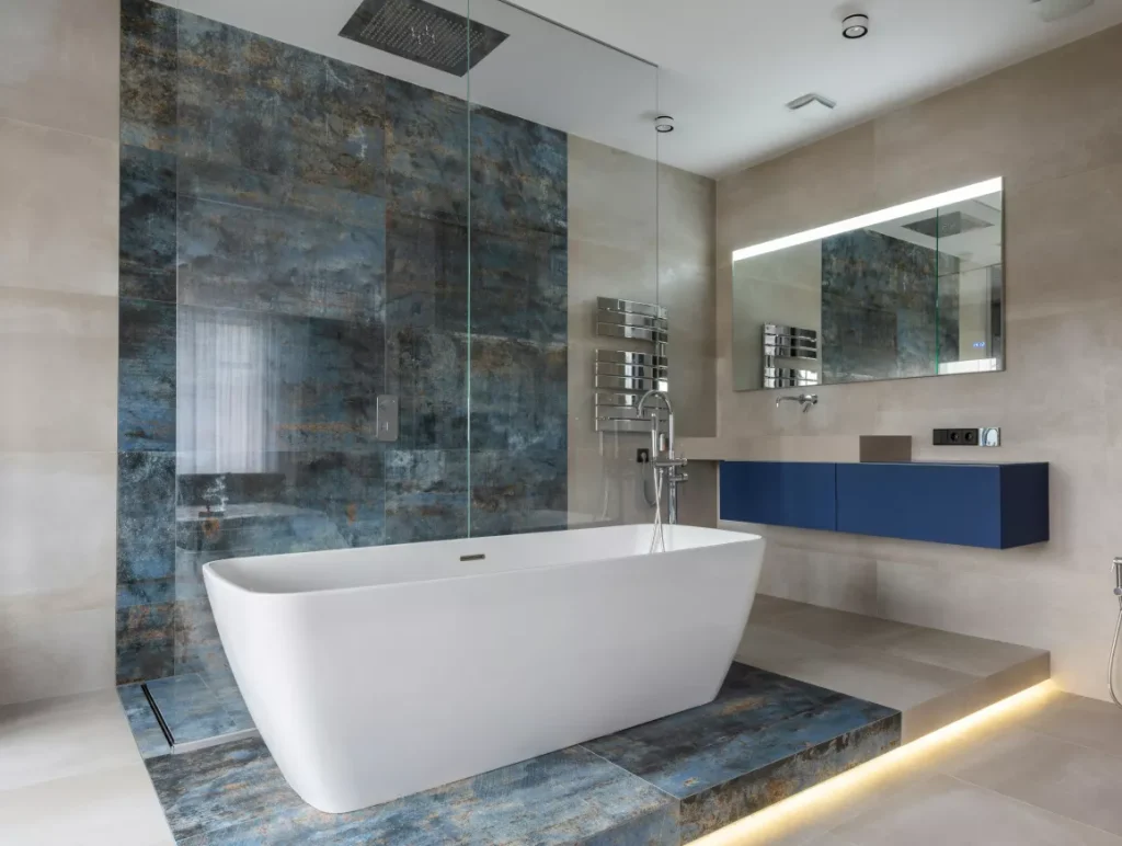 A modern bathroom featuring blue tiles and a spacious bathtub, creating a stylish and relaxing atmosphere.