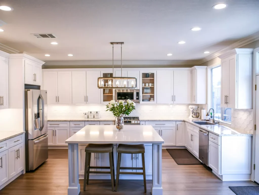 A modern kitchen featuring a central island and a refrigerator, showcasing a functional and stylish cooking space.