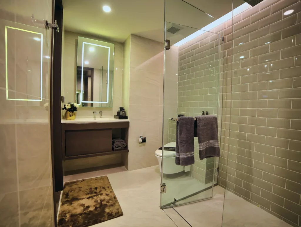 A modern bathroom featuring a glass shower door and a white toilet against neutral-colored walls.