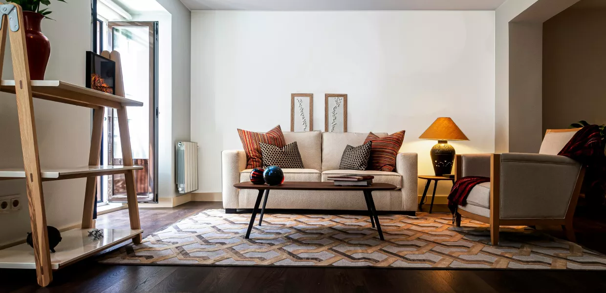 A cozy living room featuring a couch, a chair, a lamp, and a table arranged for comfort and relaxation.
